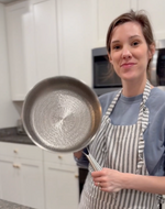 Cuisinière tenant une poêle dans sa cuisine