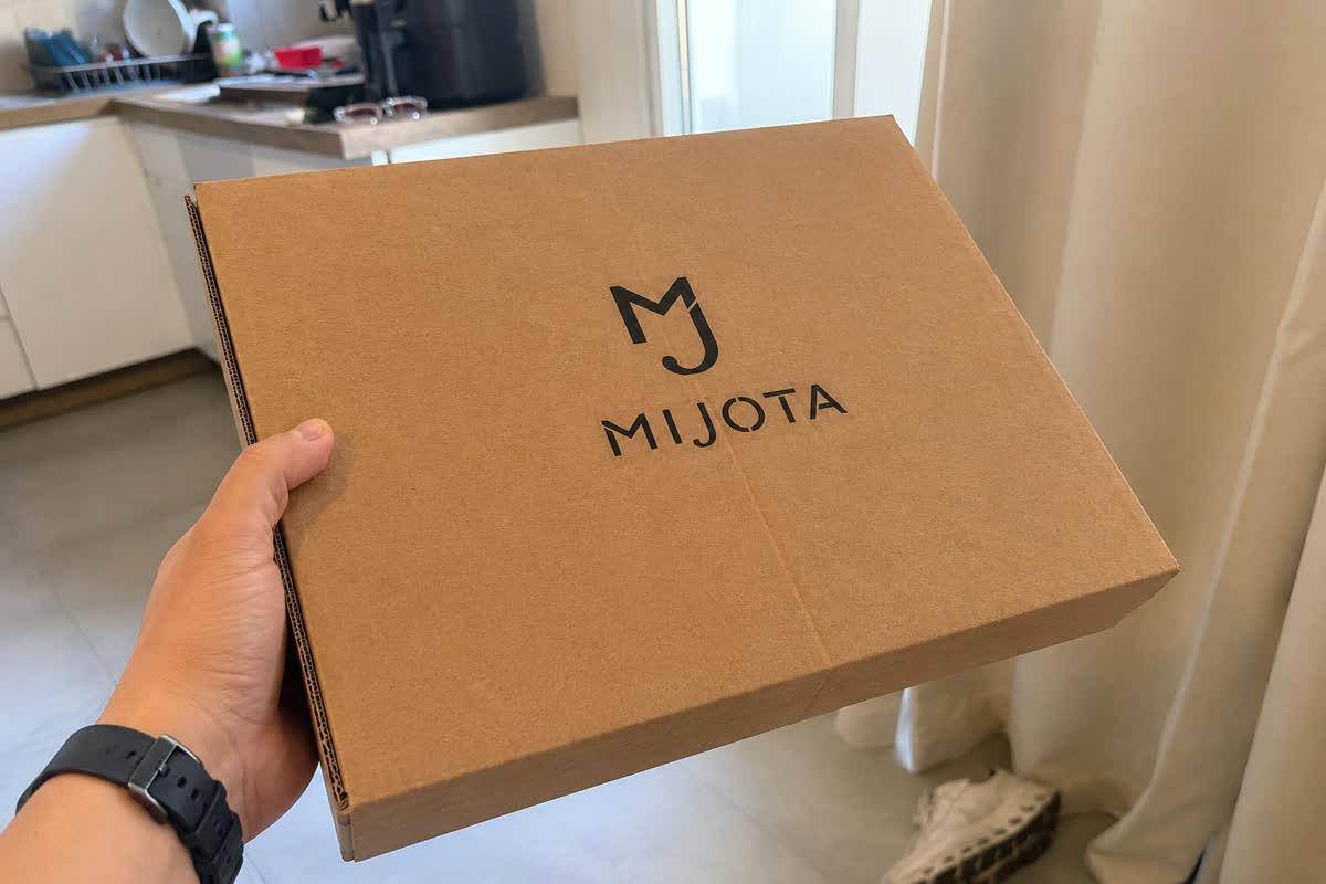 Colis MIJOTA en carton recyclé tenu à la main dans une cuisine
