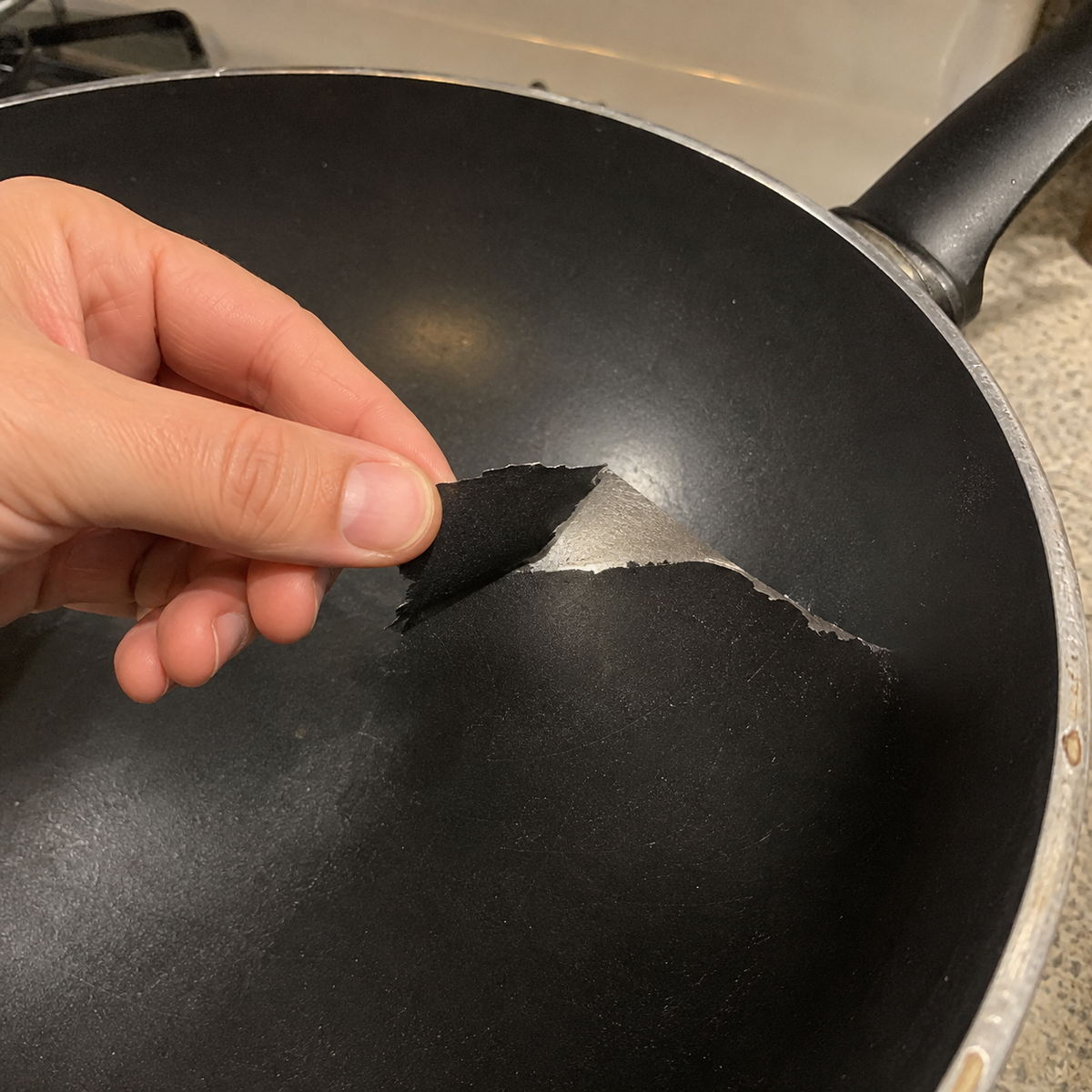 Revêtement noir usé et écaillé dans un ancien wok